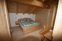 Gem&uuml;tliche Schlafzimmer mit viel Holz